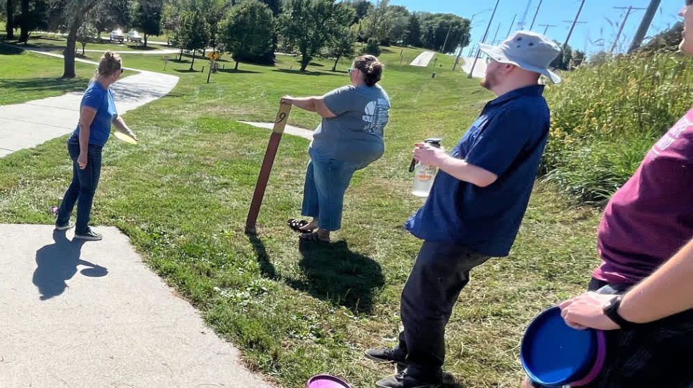 Daycos team members playing disc golf by the lake