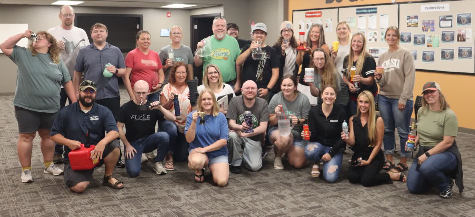 Daycos employees posing together under the Do Good & Be Good wall