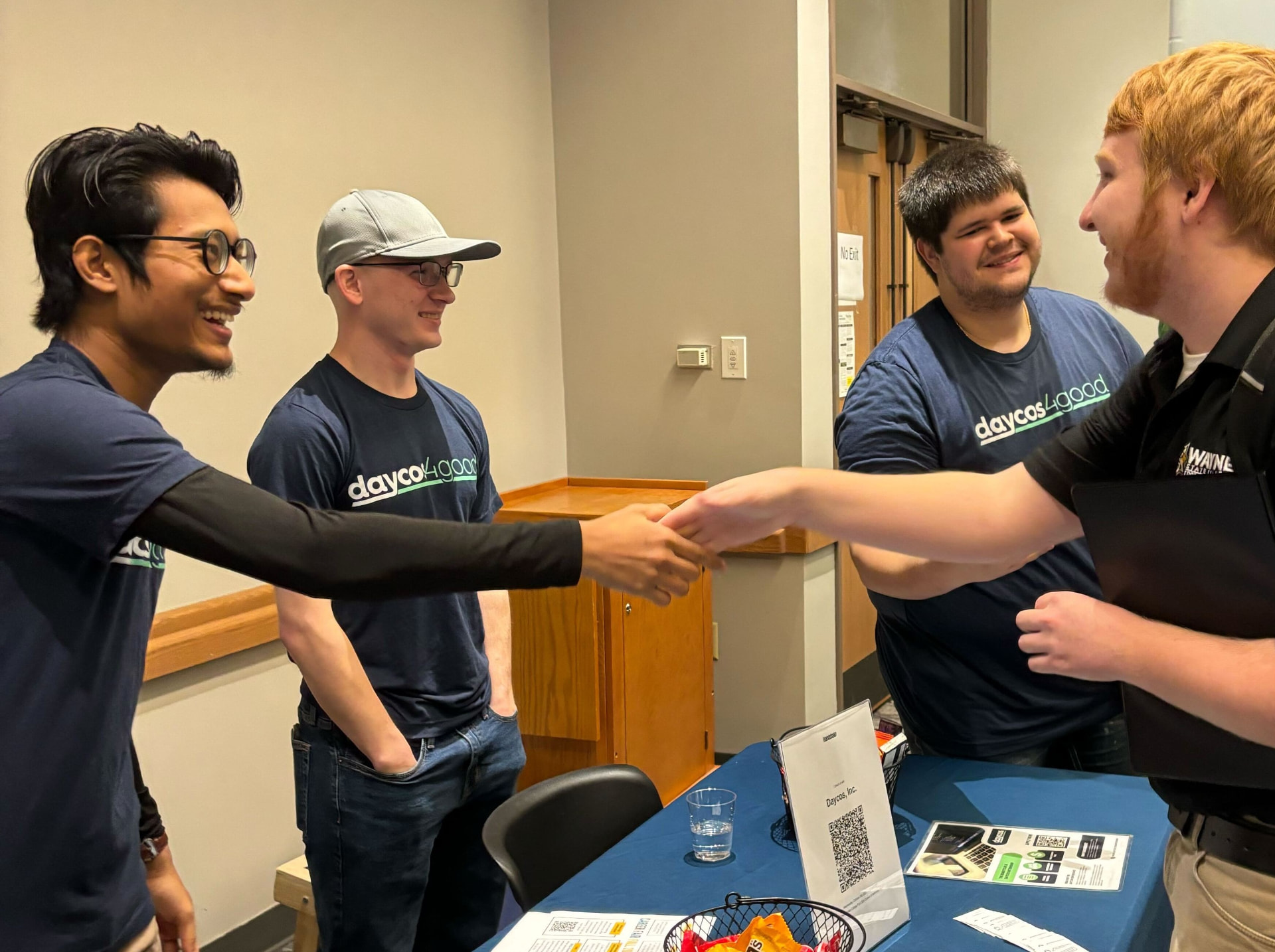 Daycos team members greeting a visitor at an event booth